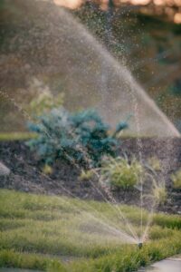 sprinklers with water streams spraying on landscaping