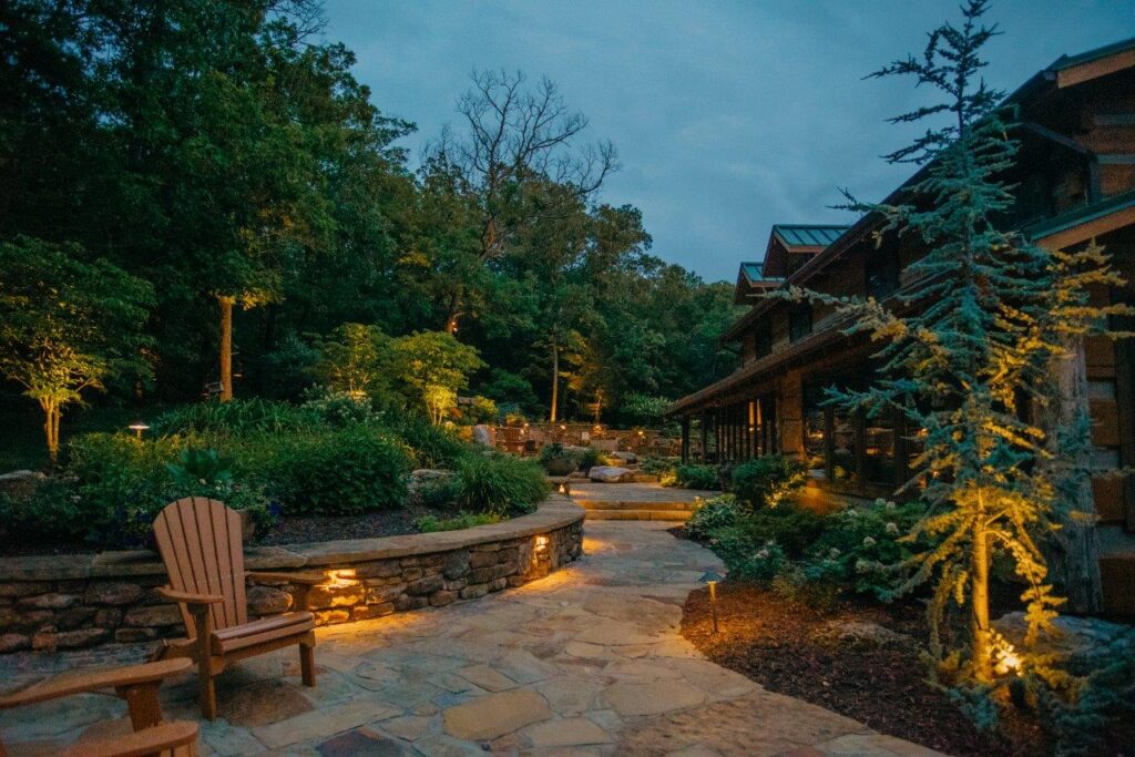 stone walkway and steps with landscaping and outdoor lighting alongside of house