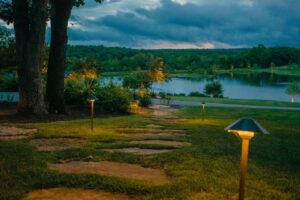 landscape lighting on either side of stepping stone path leading to lake