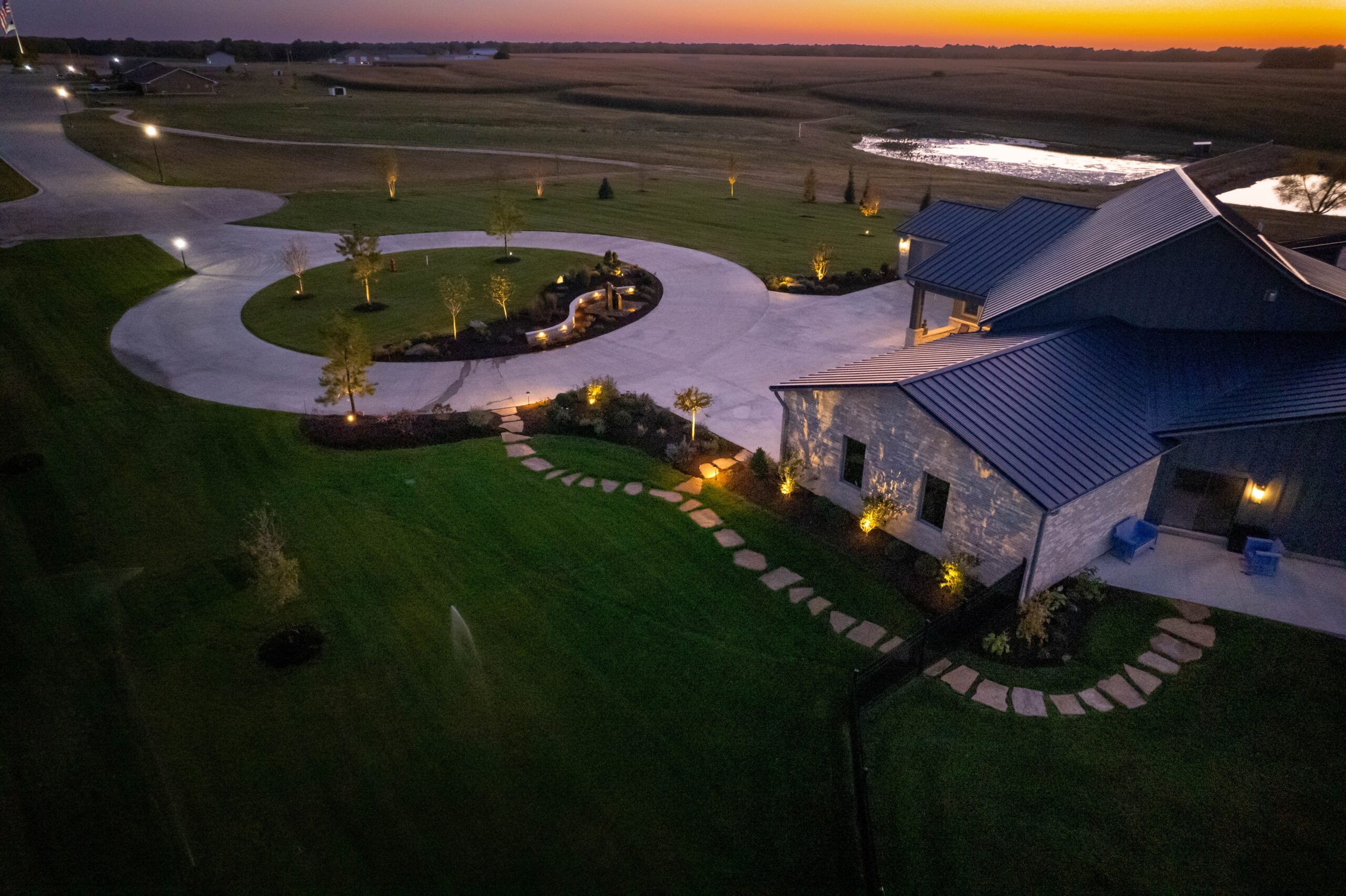 aerial view of circle drive and flagstone walkway at a house during sunset