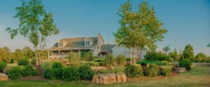 shrub, tree, and large rock landscaping around a house