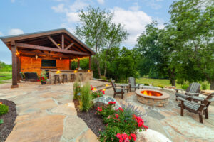 Covered outdoor kitchen with flagstone patio, stone bar, and multiple seating areas