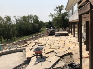 Mid installation of a flagstone patio behind a home