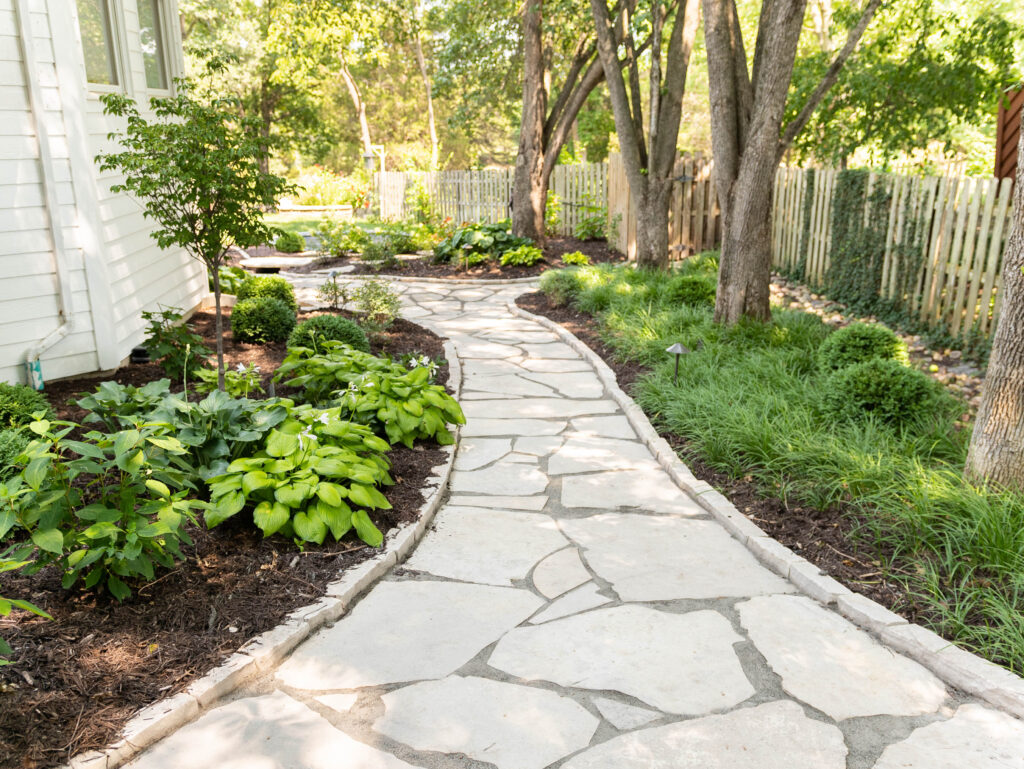 mortared flagstone walkway through a landscaped yard