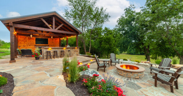 covered outdoor kitchen with bar seating and fire pit